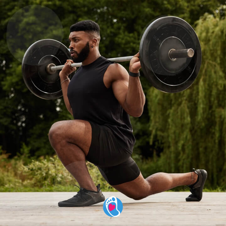 BLOG-bosa-stopka-buty-barefoot- buty-na-siłownie-vivobarefoot-buty-meskie-trening-silowy-ciezary Męczyzna robi wykrok w trakcie ćwiczeń w butach barefoot ze sztangą na ramionach - vivobarefoot