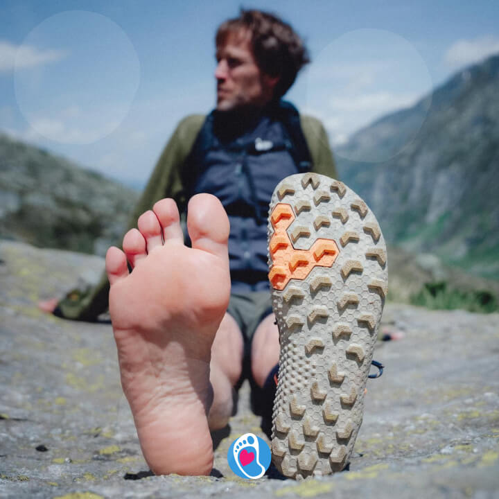Buty barefoot Vivobarefoot i naga stopa na tle gorskiego krajobrazu – naturalne czucie i przyczepnosc.