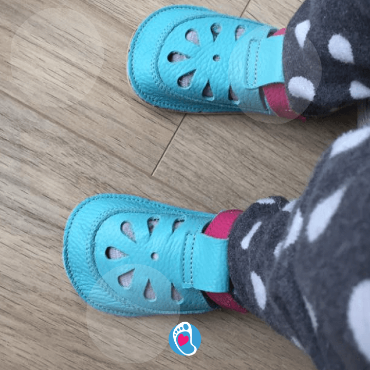 babybare-buty-barefoot-buty-dzieciece-na-drewnianej-podlodze-kropki-Bosa-Stopka. Miękkie buty dziecięce Baby Bare dla dzieci w piżamce, na jasnej podłodze. Elastyczne i anatomiczne buty barefoot
