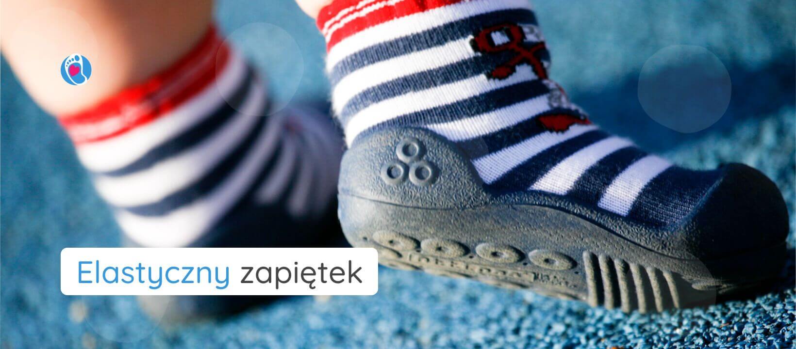Attipas–buciki-barefoot-dla-dzieci-z-kotwica–elastyczny-zapietek Elastyczne buciki barefoot Attipas z kotwicą na stopach dziecka na niebieskim podłożu