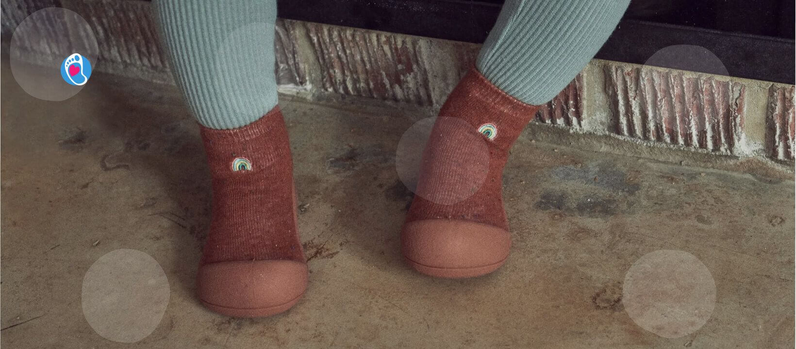 Attipas–elastyczne-buciki-barefoot-dla-dzieci–idealne-buty-do-przedszkola Bordowe buciki barefoot Attipas na stopach dziecka przy ceglanej ścianie w domu