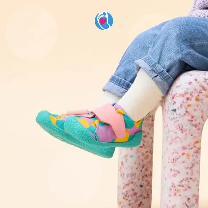 affenzahn-buty-barefoot-buty-dzieciece-kolorowe-wiosenne-krzeselko-Bosa-Stopka Kolorowe buty barefoot Affenzahn na nodze dziecka siedzacego na designerskim krzeselku. Wygodne i elastyczne buty-do-przedszkola