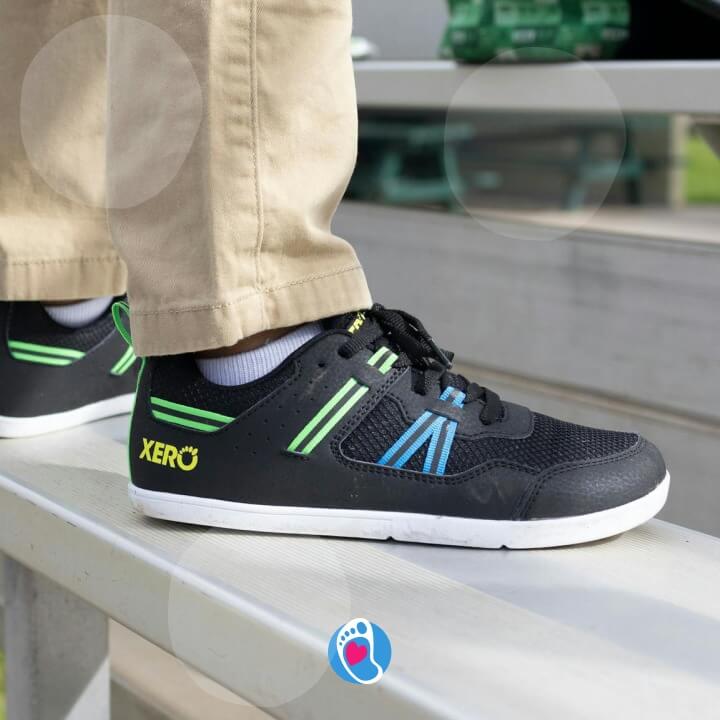 xero-shoes-prio-youth-buty-barefoot-buty-dzieciece-sportowe-czarne-ławka-Bosa-Stopka Czarne buty dziecięce Xero Shoes Prio Youth na stadionowej lawce. Idealne buty sportowe dla dzieci